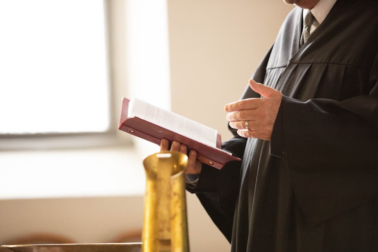 An advocate in robes holding an open law book